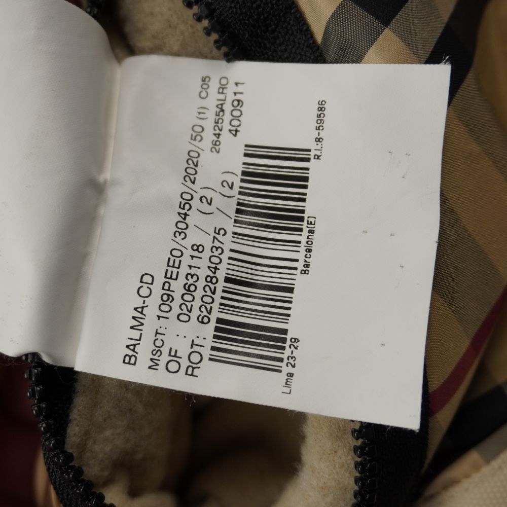 Cartellino di controllo della giacca Burberry con codice a barre e dicitura Barcellona.