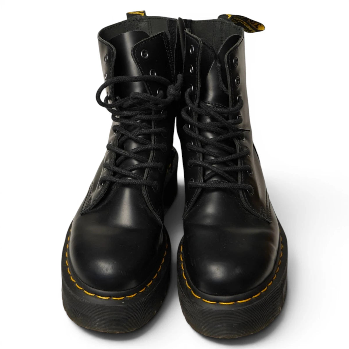 Coppia di stivali Dr. Martens stesi con evidenza degli 8 occhielli metallici neri e dei lacci.