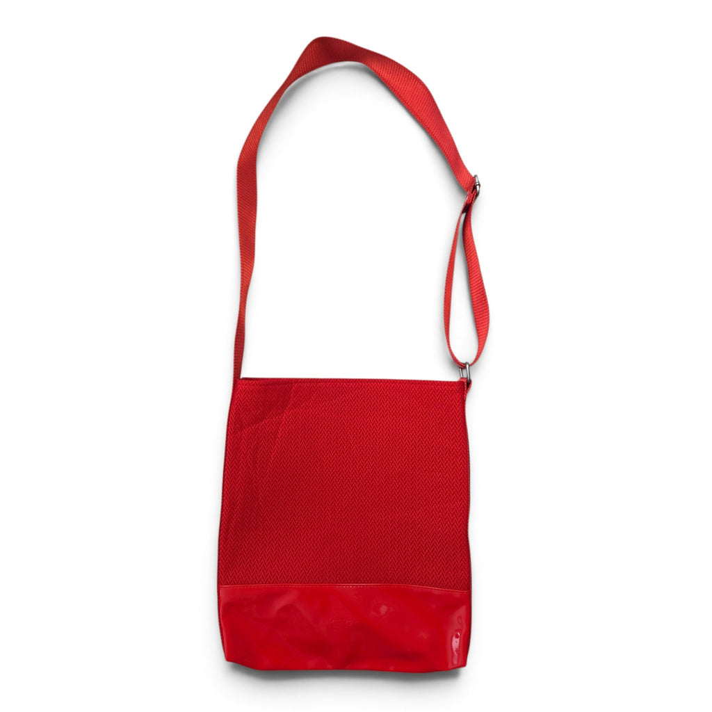 Dettaglio dei leggeri segni superficiali sulla base in vernice rossa lucida della borsa.
