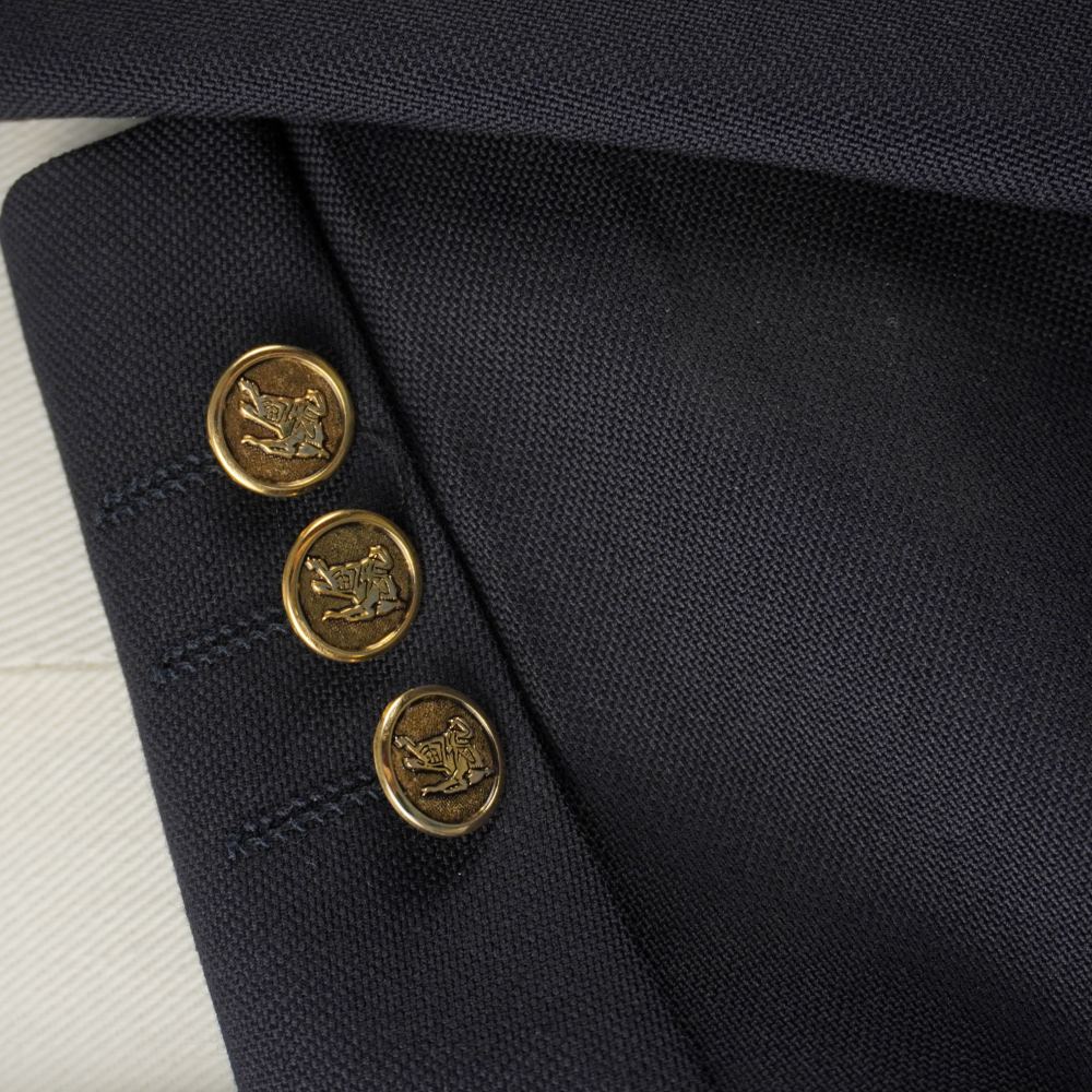 Dettaglio dei tre bottoni dorati logati sul polsino del blazer.