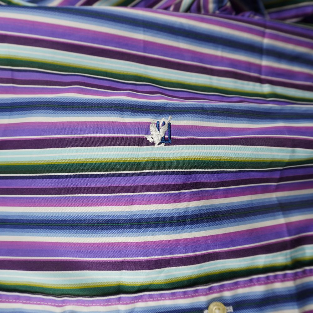 Dettaglio del logo Pegaso bianco ricamato sul petto della camicia Etro.