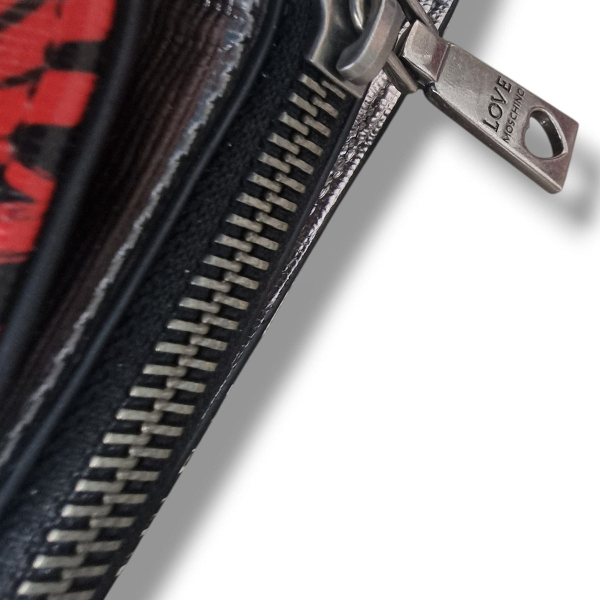  Dettaglio ravvicinato della cerniera in metallo con cursore inciso Love Moschino.