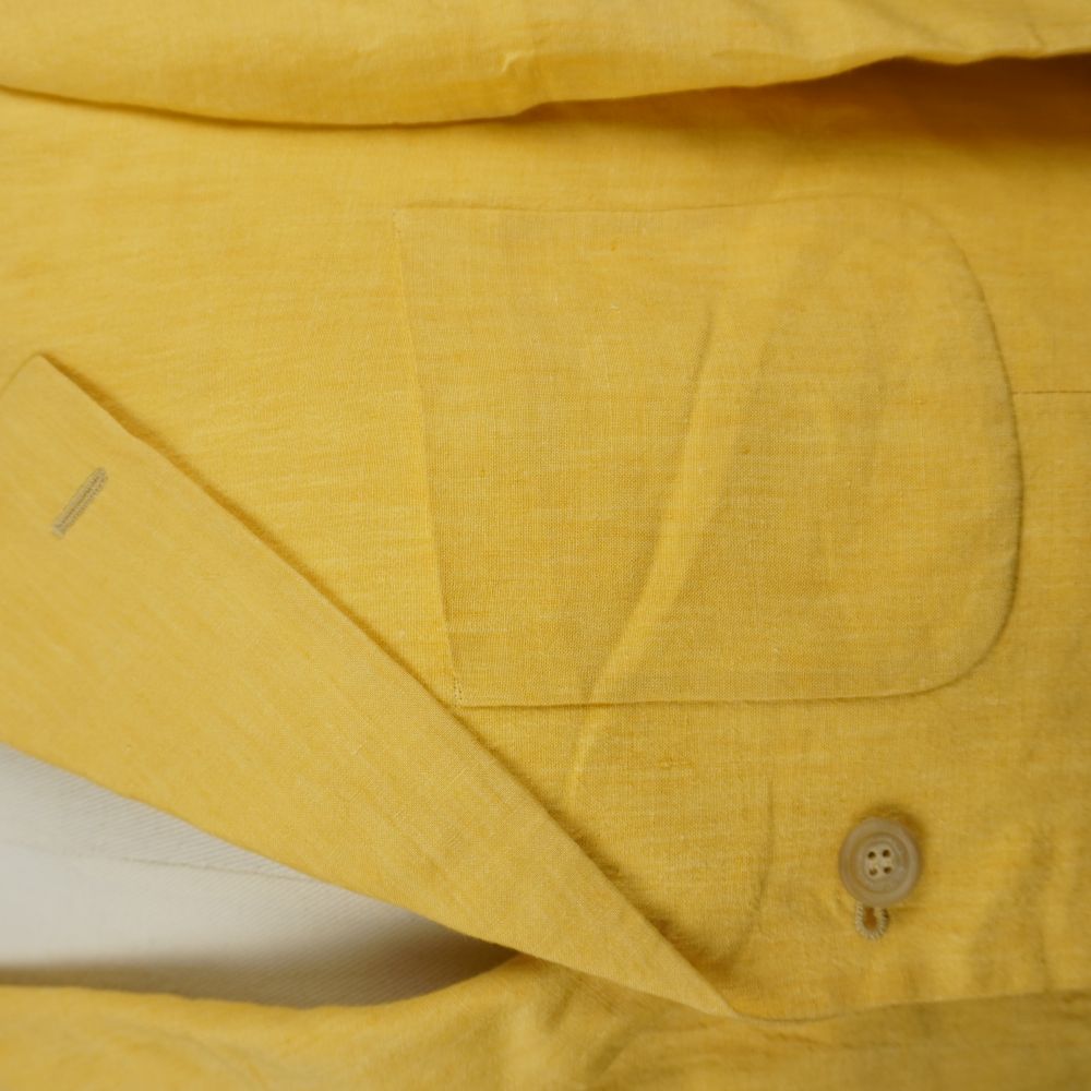 Dettaglio taschino a barchetta e rever giacca in lino giallo Etro.