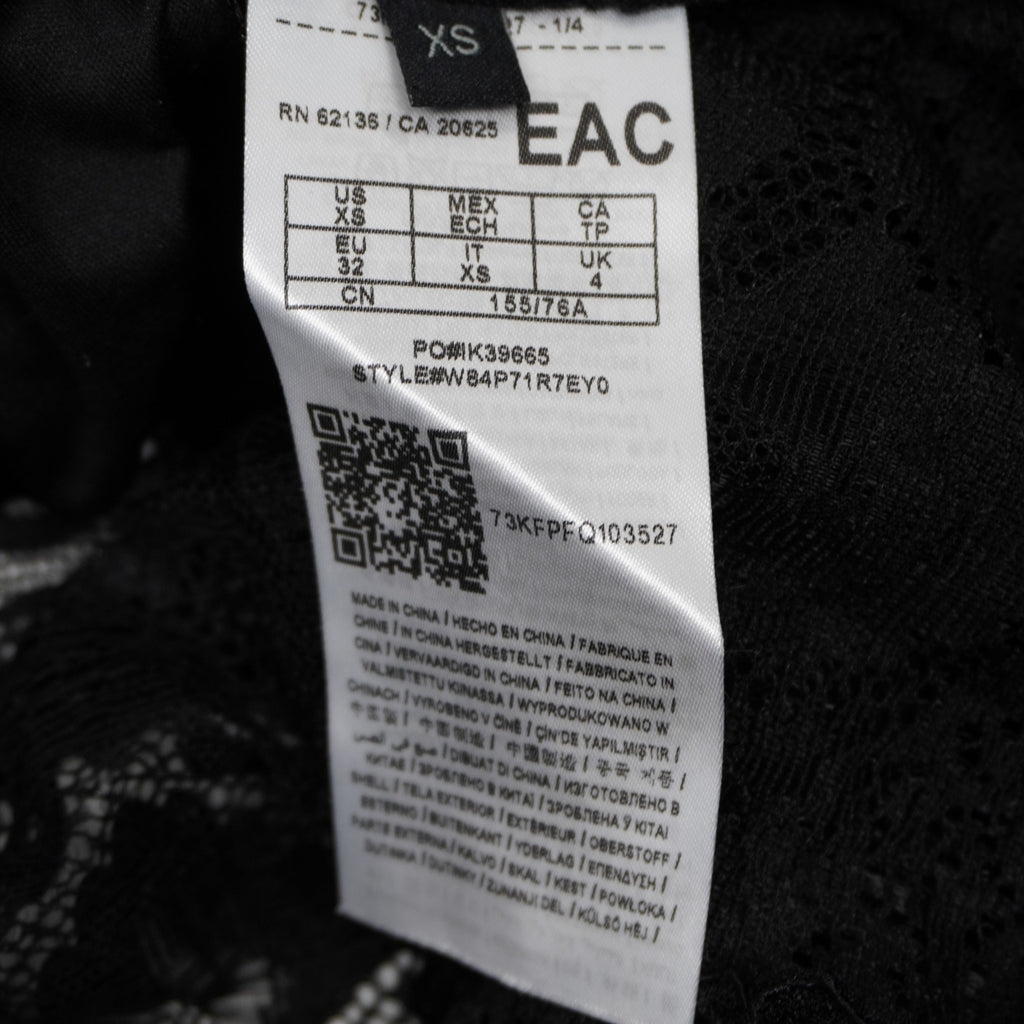 Etichetta di composizione Guess con indicazione taglia XS e codice stile.