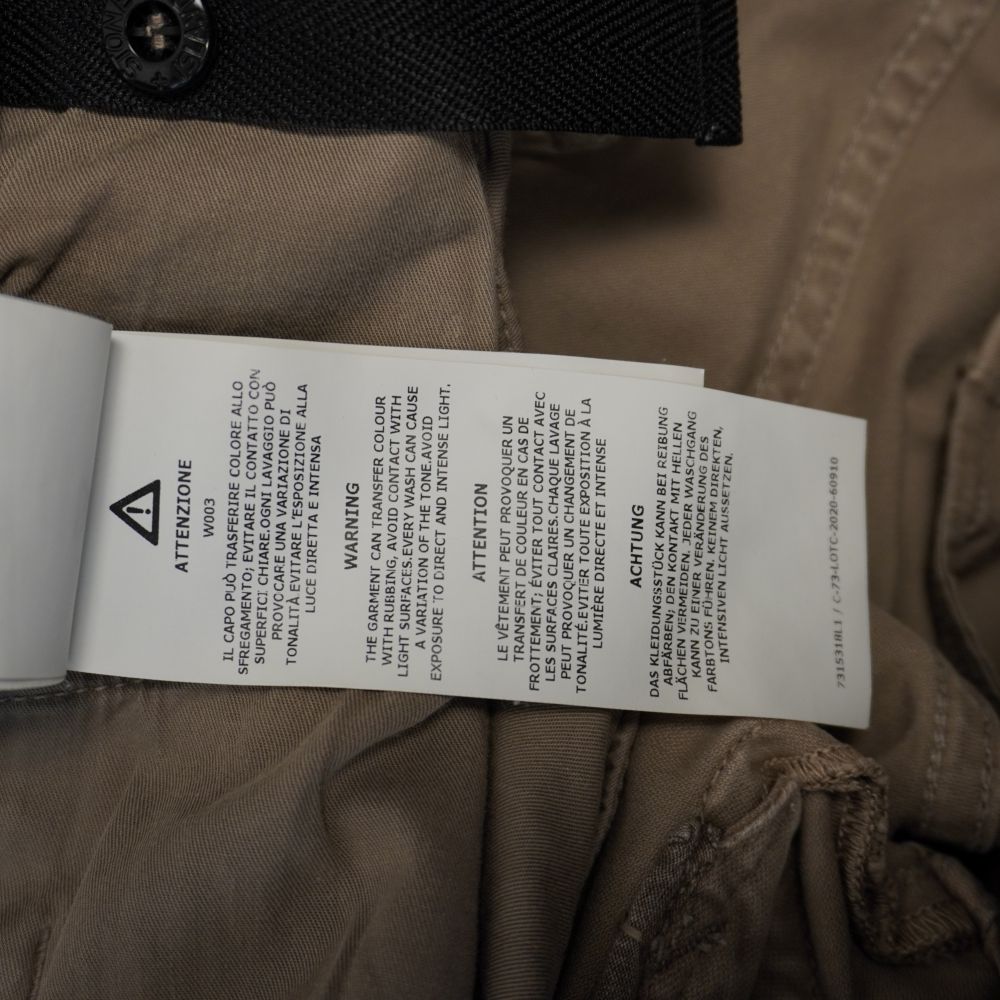 Etichetta interna Stone Island con avvertenze sul lavaggio e trasferimento colore multilingua (Codice W003).