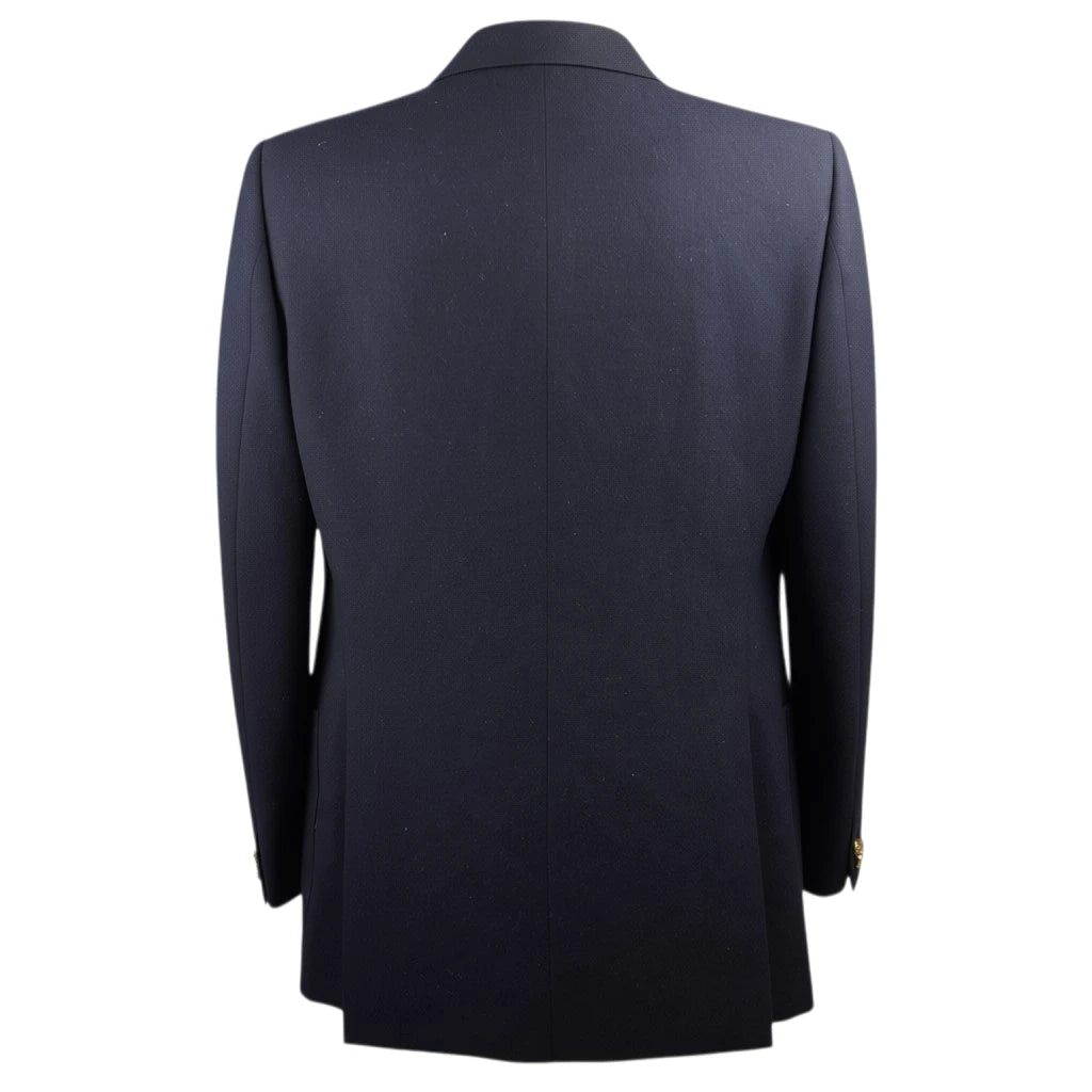 Inquadratura posteriore della giacca sartoriale blu navy con cucitura centrale pulita.