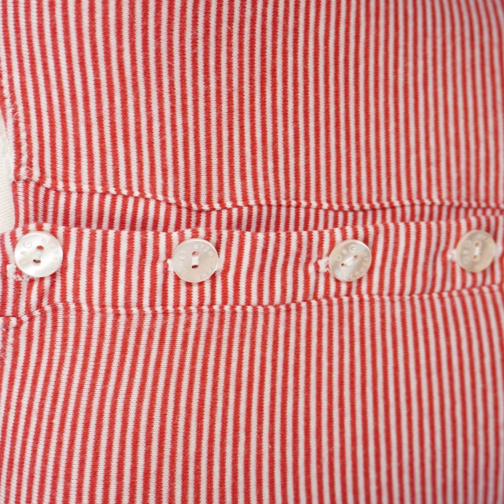  Inquadratura ravvicinata dei quattro bottoni bianchi logati D&G Underwear sullo scollo a costine.