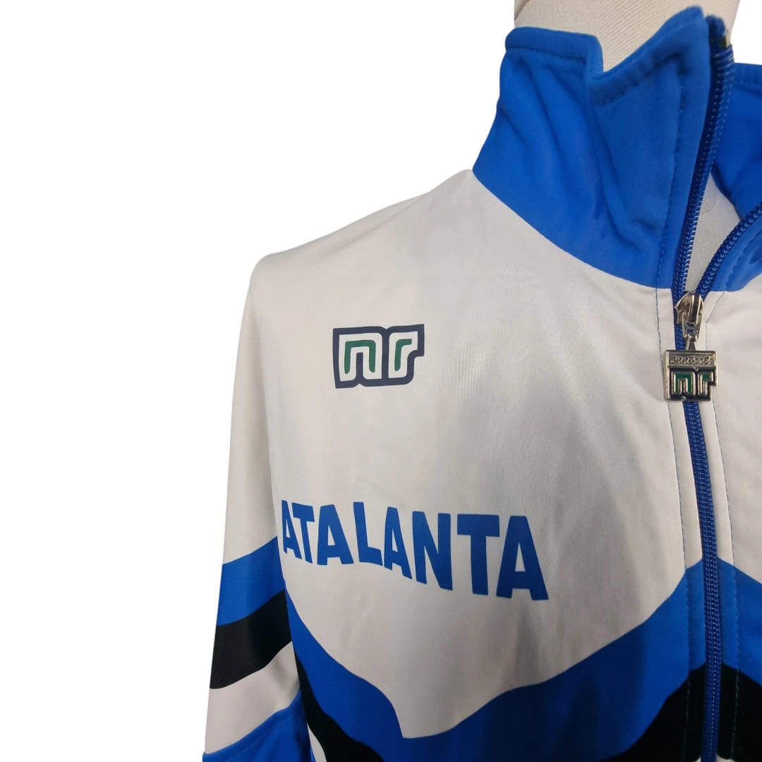 Lato destro del petto con scritta stampata blu Atalanta e logo nr Ennerre a rilievo.