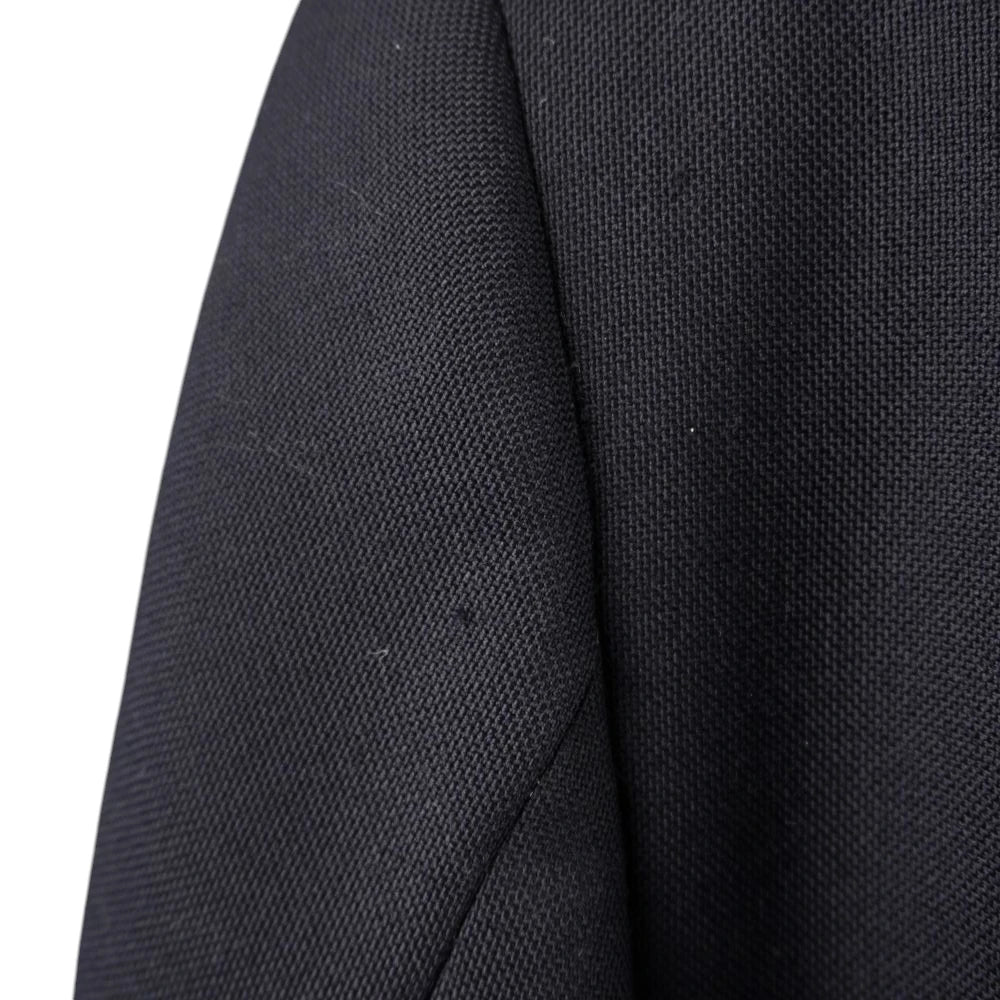 Particolare del tessuto blu navy e della cucitura della manica.
