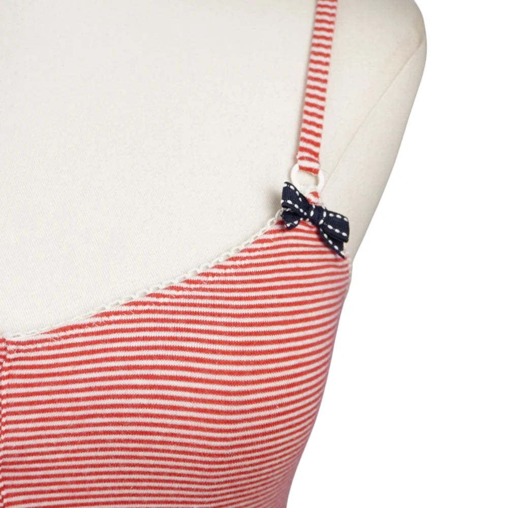 Primo piano della spallina sottile regolabile con piccolo fiocco blu navy a pois bianchi.