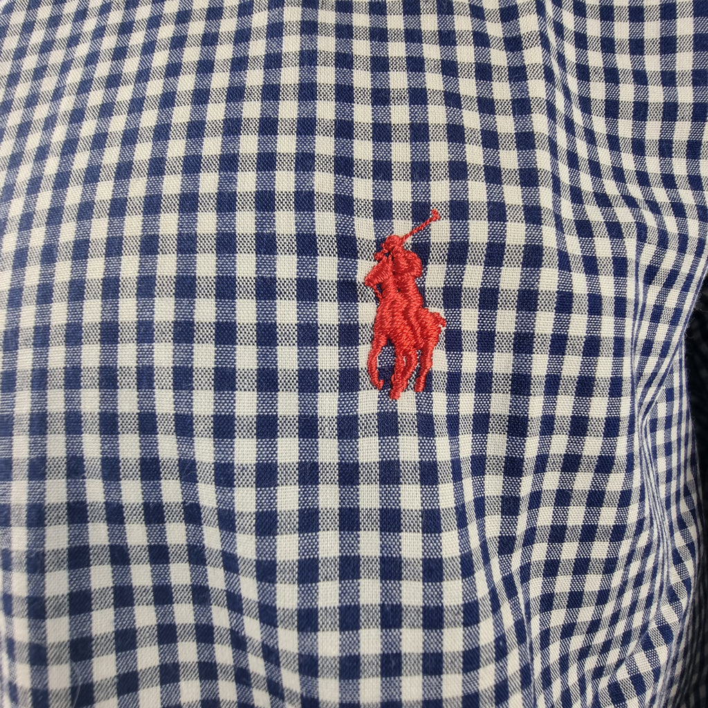  Ricamo ravvicinato del classico pony rosso Ralph Lauren sulla trama a quadretti blu e bianchi.