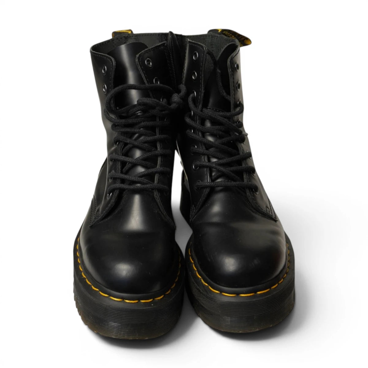Vista frontale del paio di anfibi neri platform Dr. Martens Jadon con lacci e cuciture gialle.