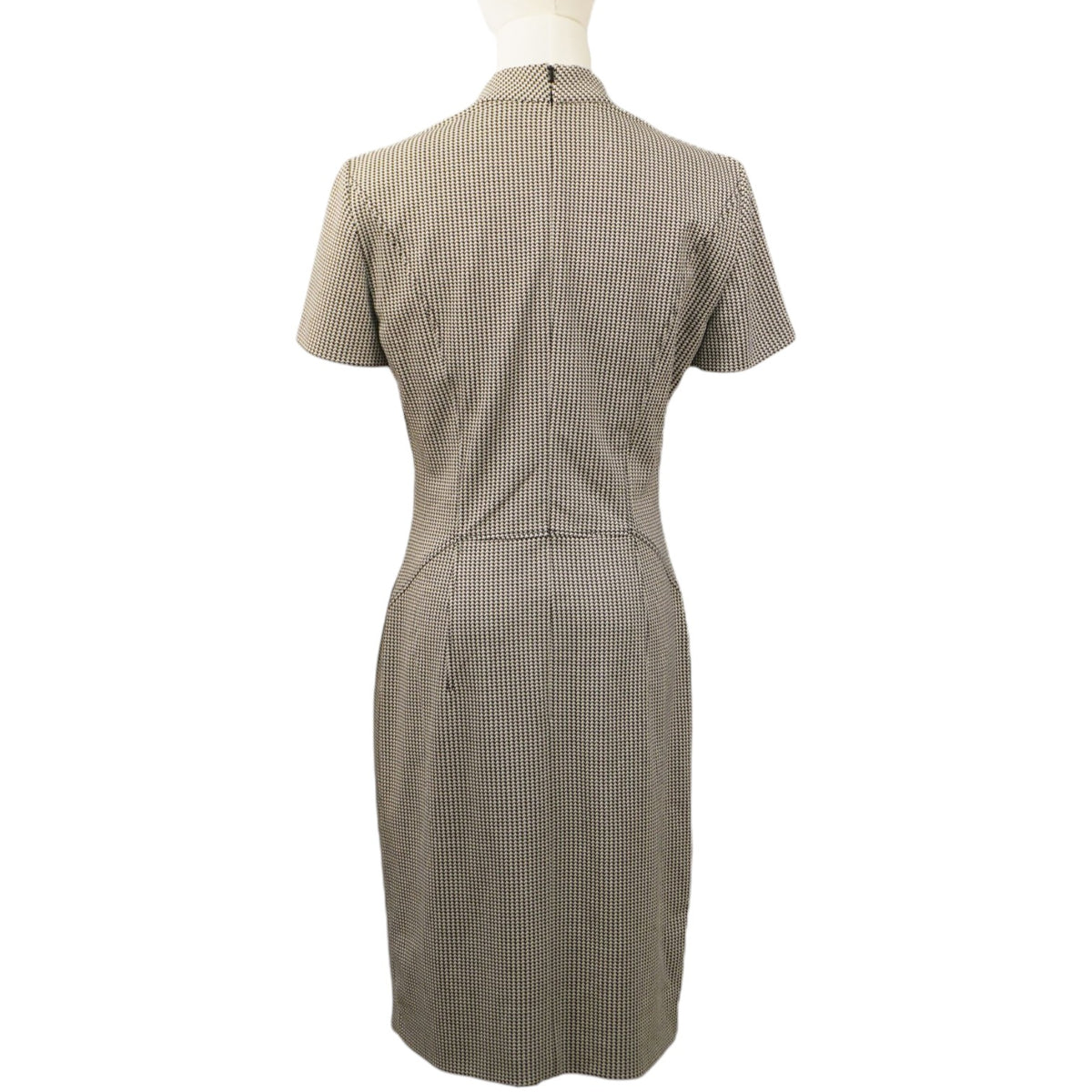 Vista posteriore dell'abito a tubino pied-de-poule sul manichino, che mostra il taglio slim fit e la cerniera centrale.
