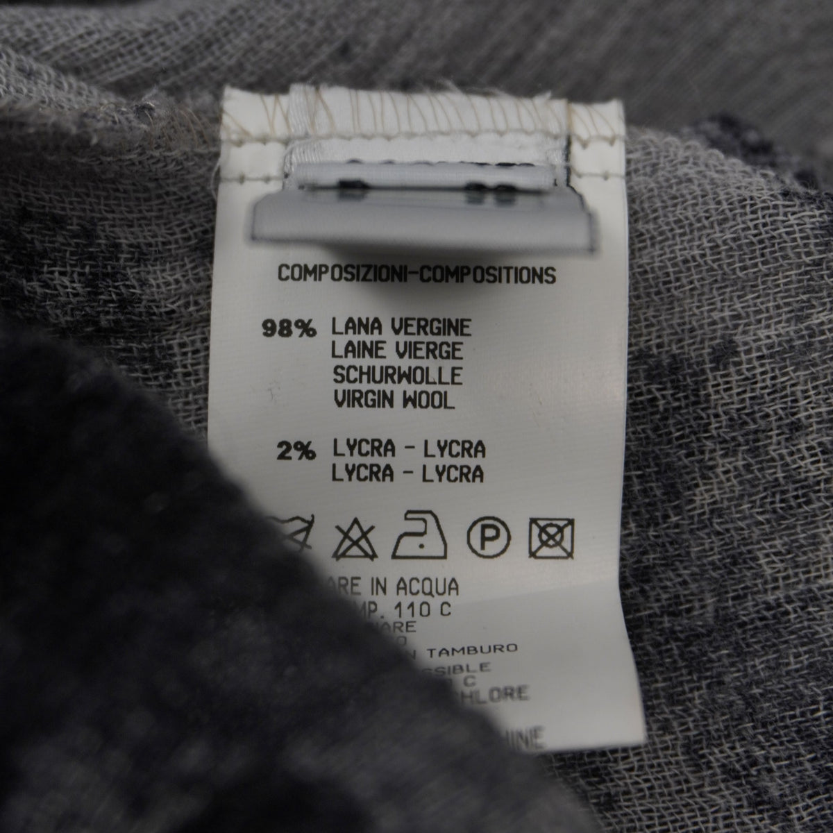 Etichetta di composizione che certifica l'utilizzo di 98% pregiata lana vergine e 2% Lycra stretch.