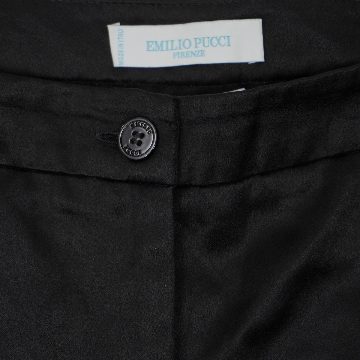 Primo piano della chiusura frontale con bottone e patta sartoriale dei pantaloncini neri Emilio Pucci.