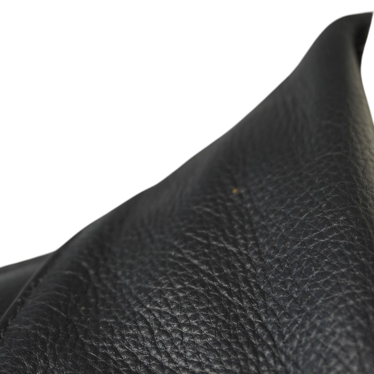 Inquadratura ravvicinata e inclinata della texture della pelle martellata nera e di una cucitura lineare.