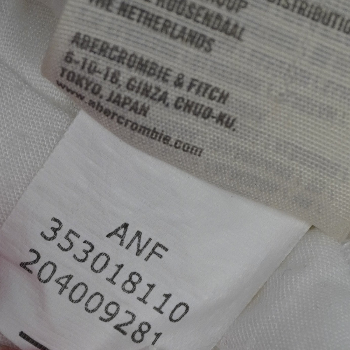 Macro dell'etichetta interna di tracciabilità con i dati del gruppo Abercrombie & Fitch e il codice numerico ANF 353018110.