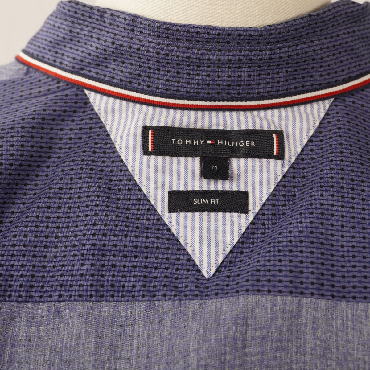 Dettaglio etichetta Tommy Hilfiger sul colletto interno con profilo tricolore iconico del brand