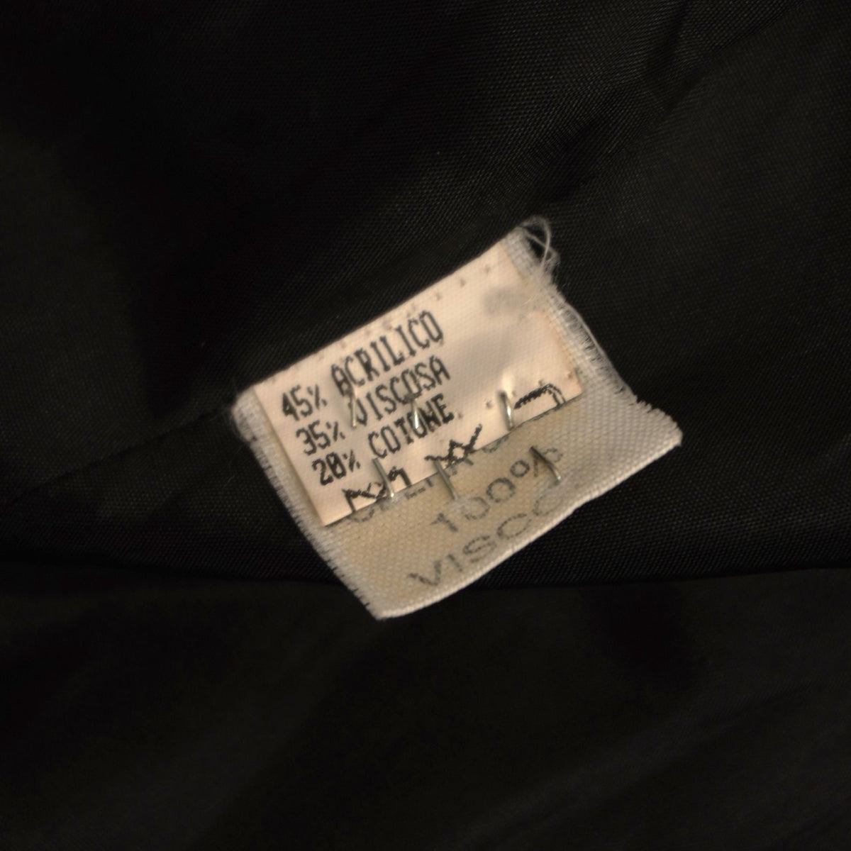 Etichetta interna cartacea con le percentuali di acrilico, viscosa e cotone e le istruzioni di lavaggio della giacca vintage Pavarotti.