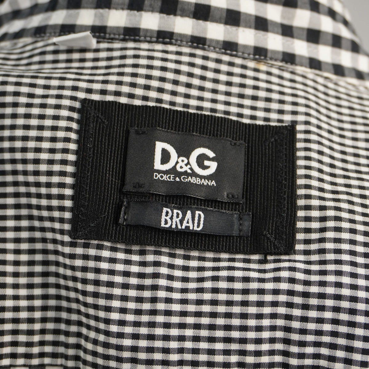 Primo piano dell'etichetta nera ricamata D&G Dolce & Gabbana con indicazione del modello Brad, cucita nel colletto.