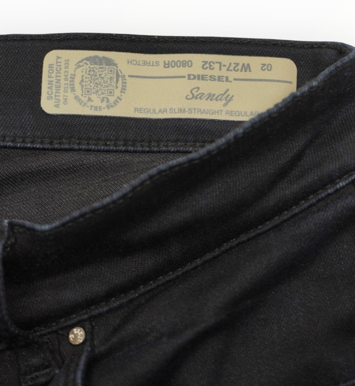 Particolare dell'etichetta beige ricamata cucita all'interno del fascione posteriore della vita dei jeans Diesel.