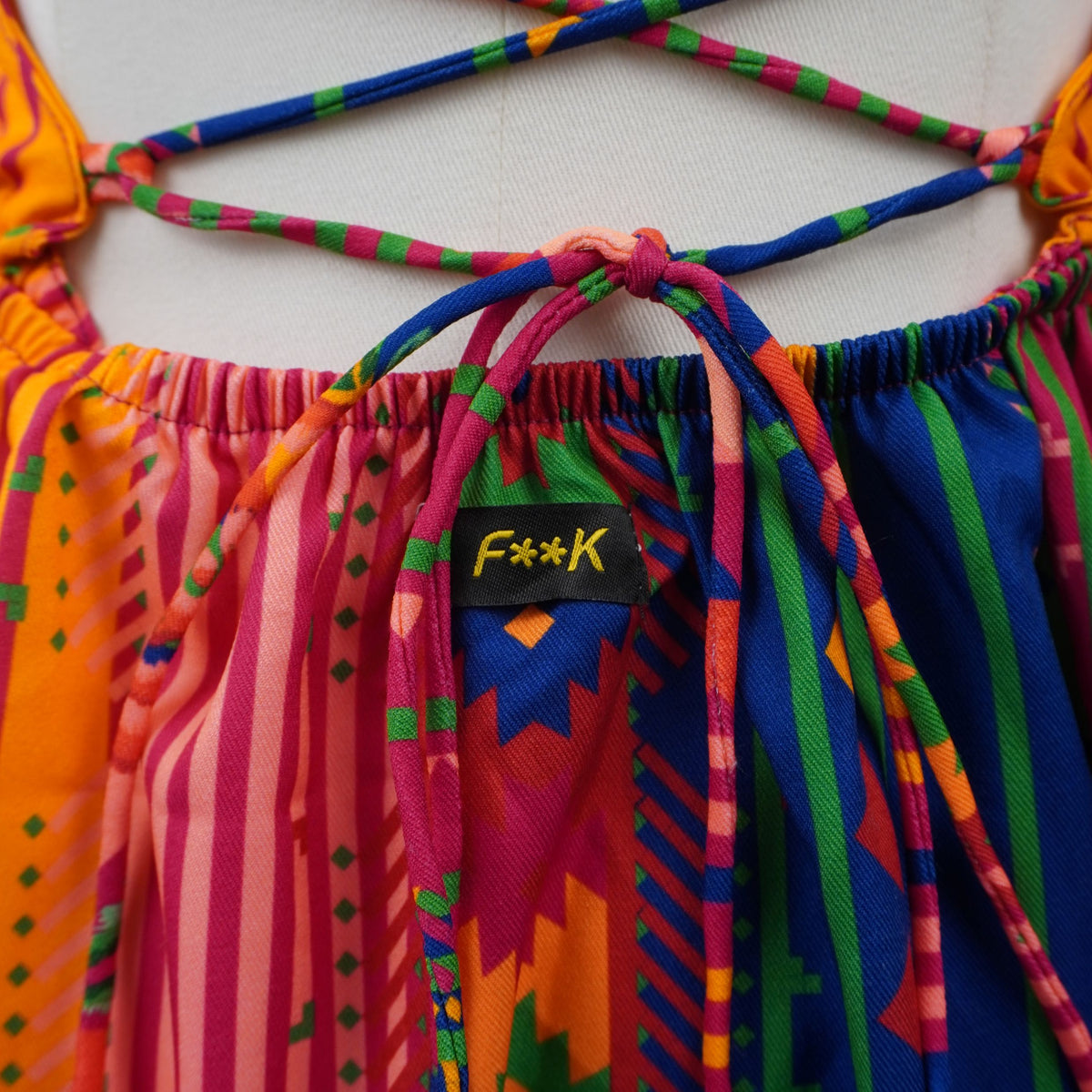 Scatto ravvicinato dell'intreccio posteriore a corsetto con etichetta del logo F**K ricamato.