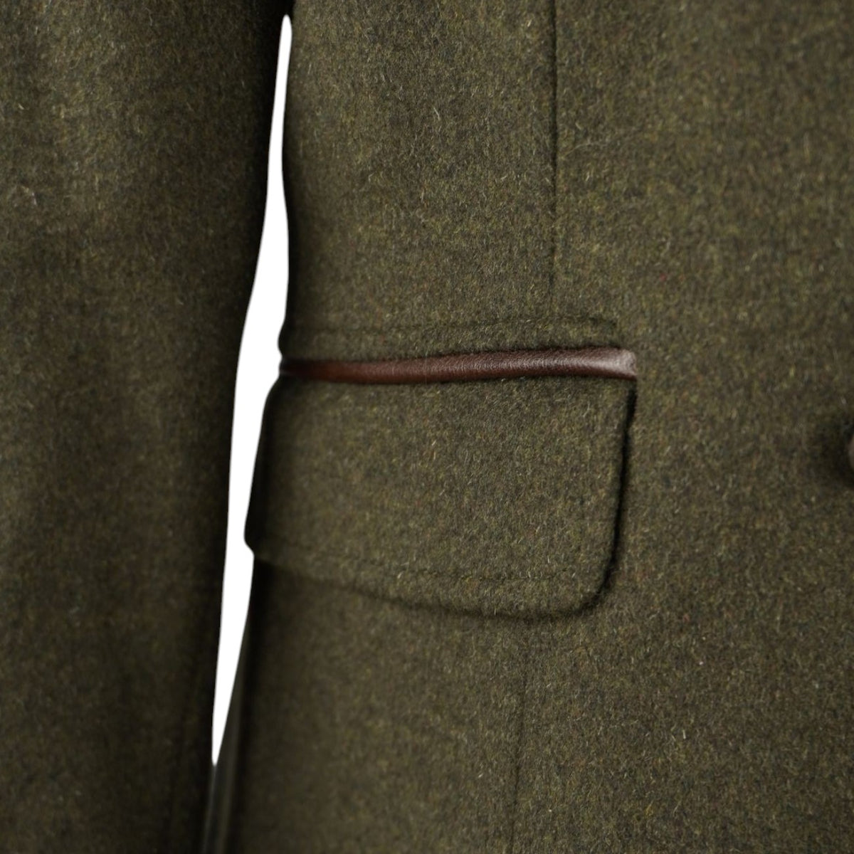 Primo piano della tasca con patta geometrica e profilo in ecopelle marrone della giacca Barbour.