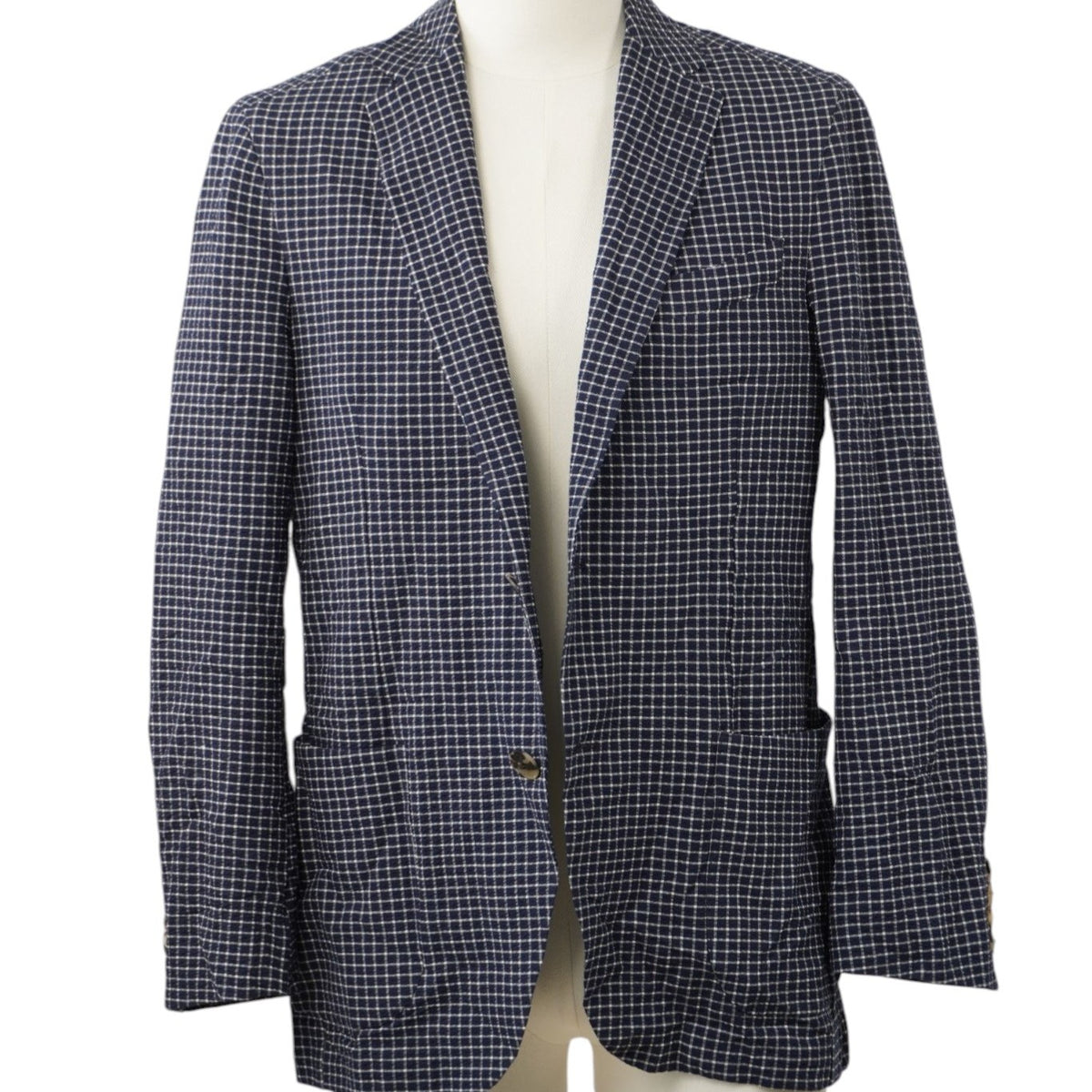 Vista frontale su manichino di una giacca monopetto Etro Milano a micro-quadretti blu e bianchi con tasche a toppa frontali.