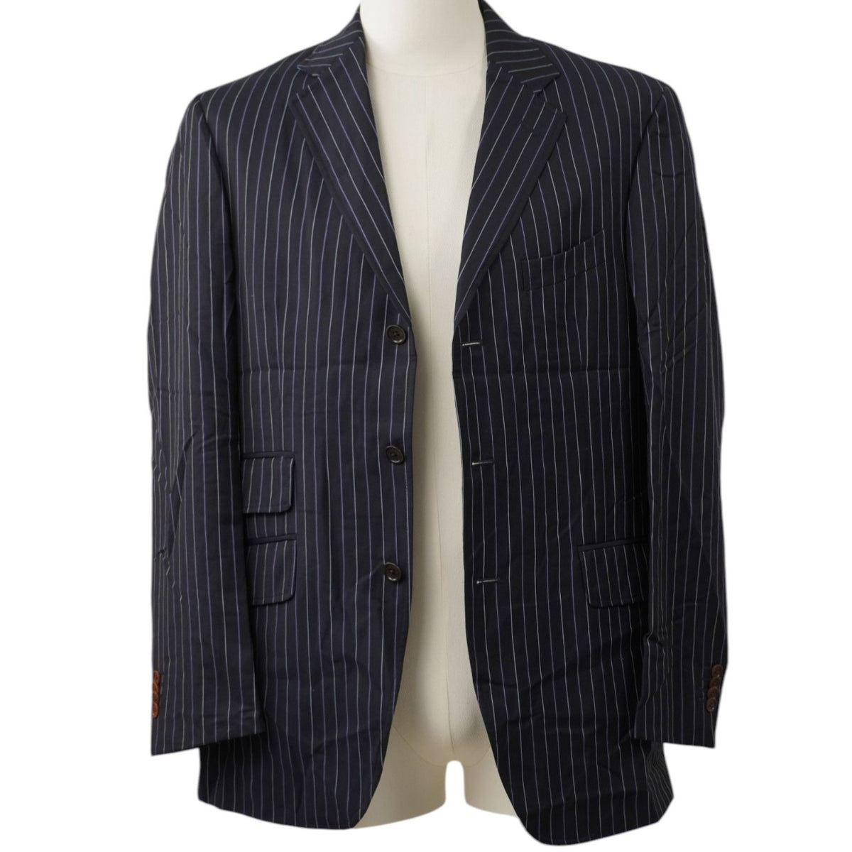 Vista frontale su manichino di una giacca monopetto gessata Etro Milano in lana blu navy con tasche a filetto e patta frontali.