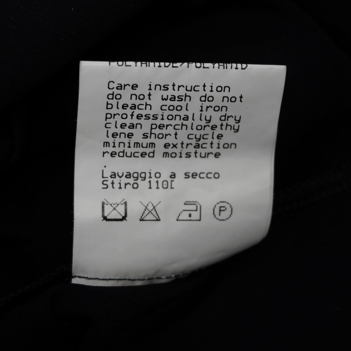 Particolare dell'etichetta con i simboli per il lavaggio e la cura del tessuto in viscosa elasticizzata.