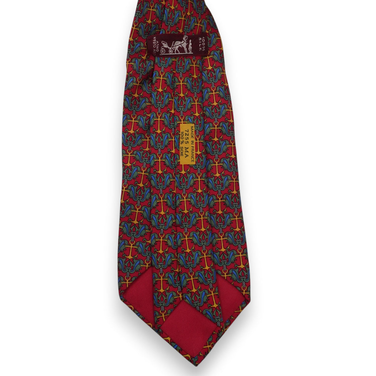 Vista posteriore del retro della cravatta rossa Hermès con il passante istituzionale marrone e le stampe di autenticità sulla seta.