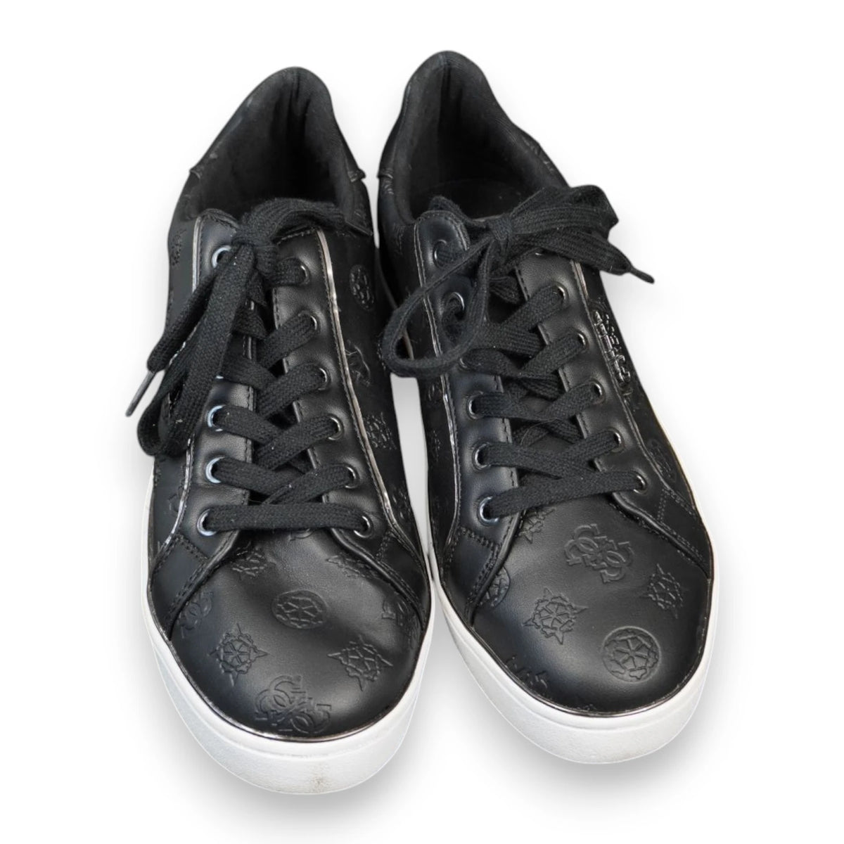 Inquadratura dall'alto a tre quarti di un paio di sneakers nere Guess con stringhe nere