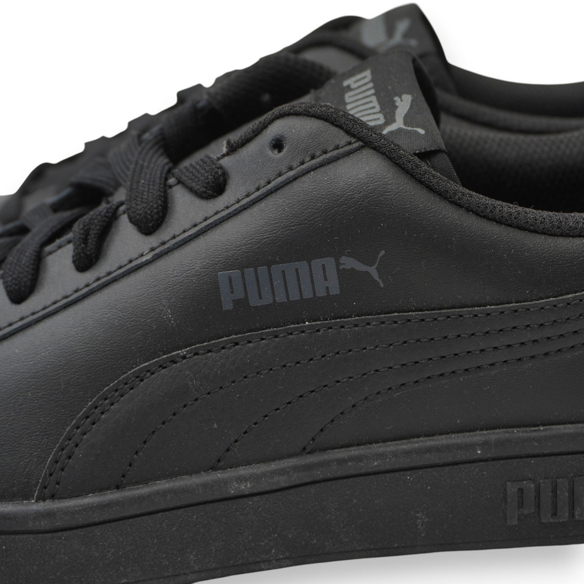 Primo piano del logo PUMA impresso sul pannello laterale in pelle delle sneaker Smash.