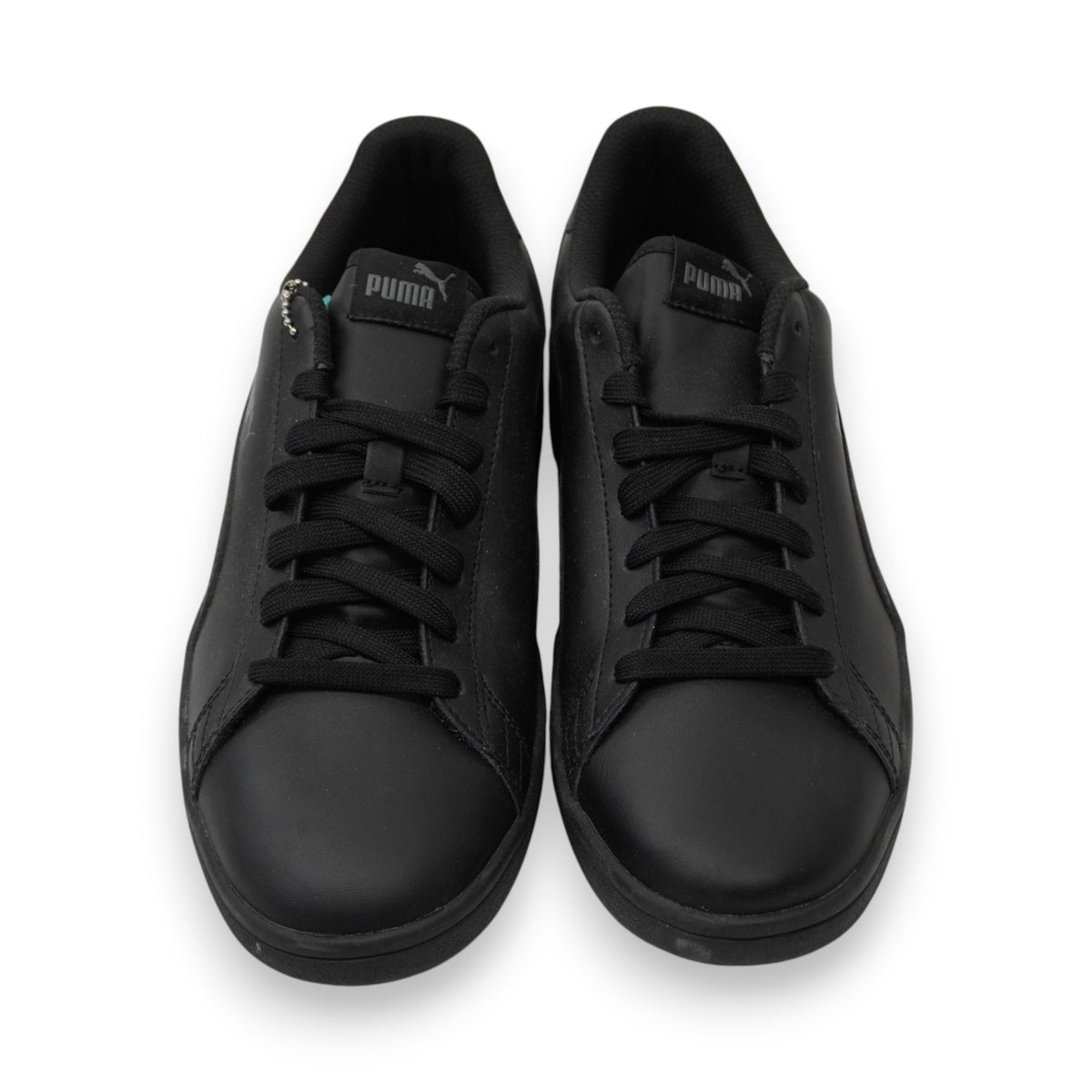 Inquadratura frontale simmetrica del paio di sneaker da uomo PUMA Smash in pelle nera.