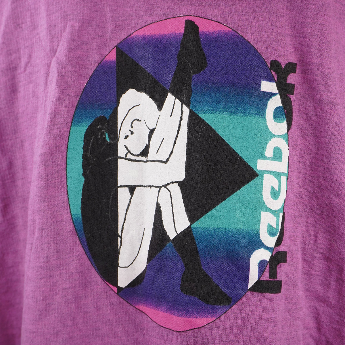 Macro della stampa serigrafica posteriore tonda in stile vaporwave con illustrazione geometrica di una ginnasta e scritta Reebok.